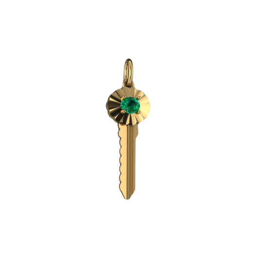 A gold key pendant with an oval-cut emerald in a scalloped frame, set against a white background.