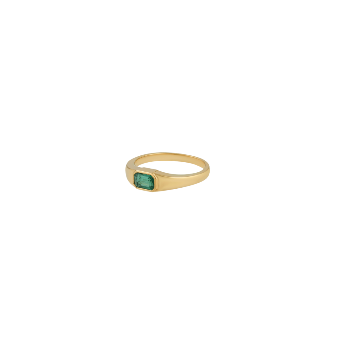 A gold signet ring featuring a rectangular green emerald-cut gemstone, shown against a plain white background.