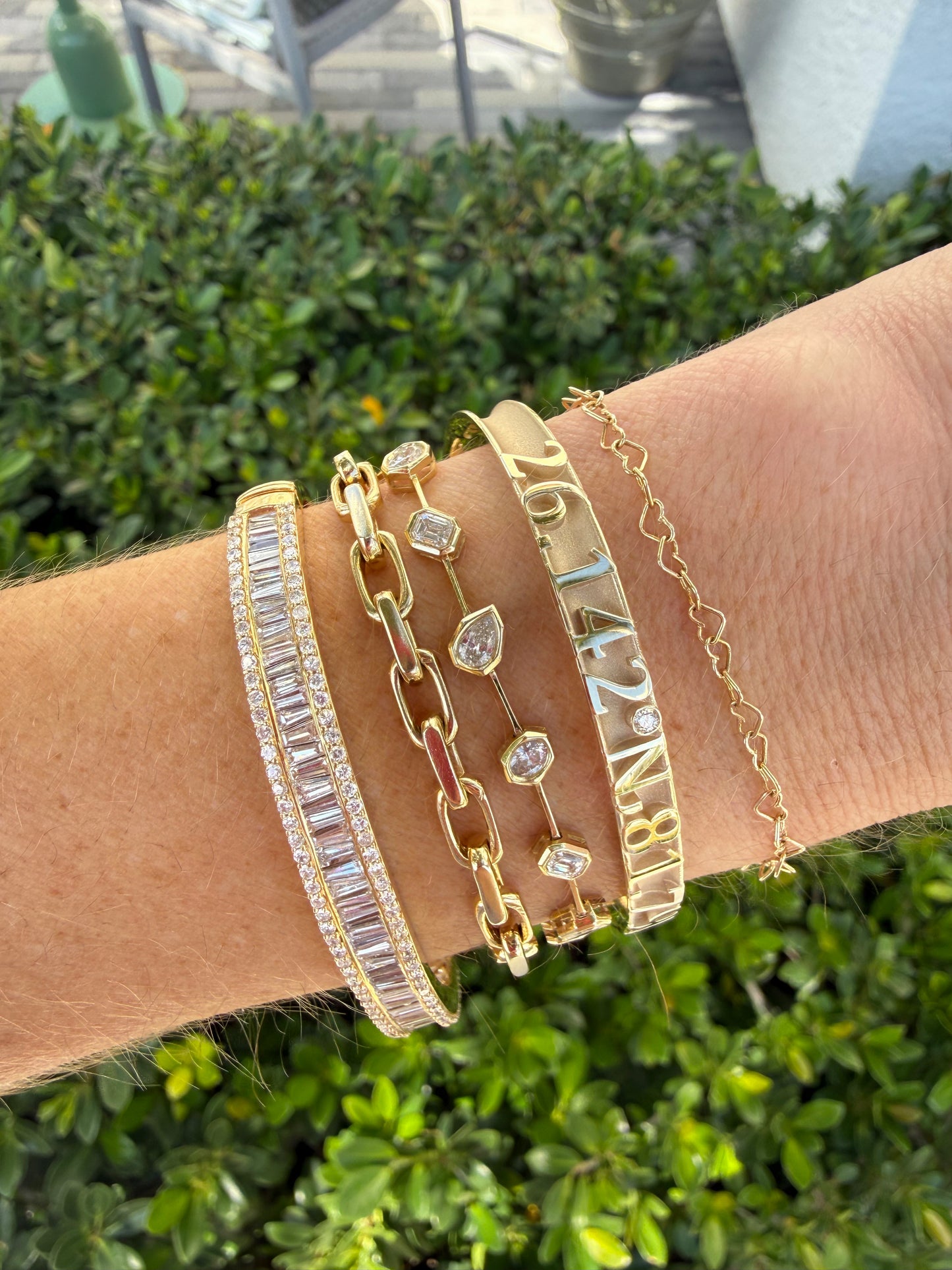 Gold bracelets with numbers and gemstones on a wrist
